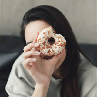 Gesunde Sacks mit Geschmackspulver: Frau mit Donut