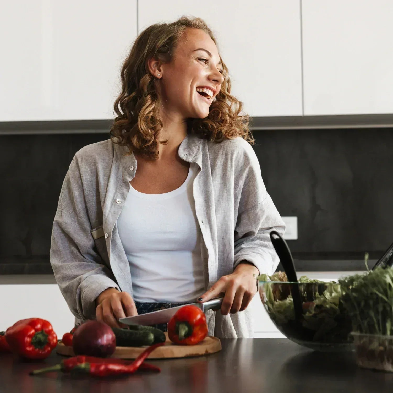 Frau schneidet Paprikas