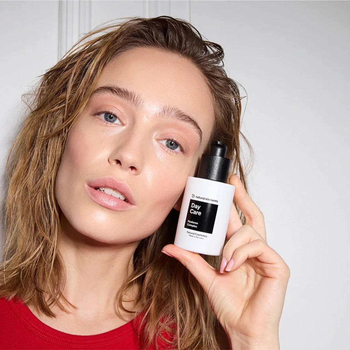 Frau mit Day Care Serum, Hyaluroncreme in der Hand für die Haut