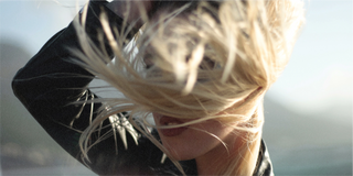 Das Haar einer Frau wird sanft vom Wind gestreichelt und umarmt die natürlichen Elemente.